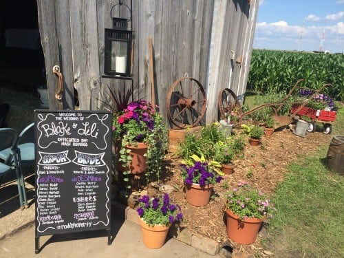 No programs, just an adorable chalkboard next to beautiful landscaping outside the ceremony barn. 