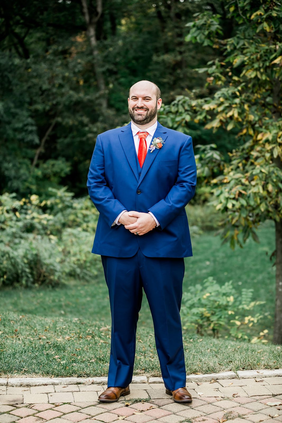groom in blue suit in park