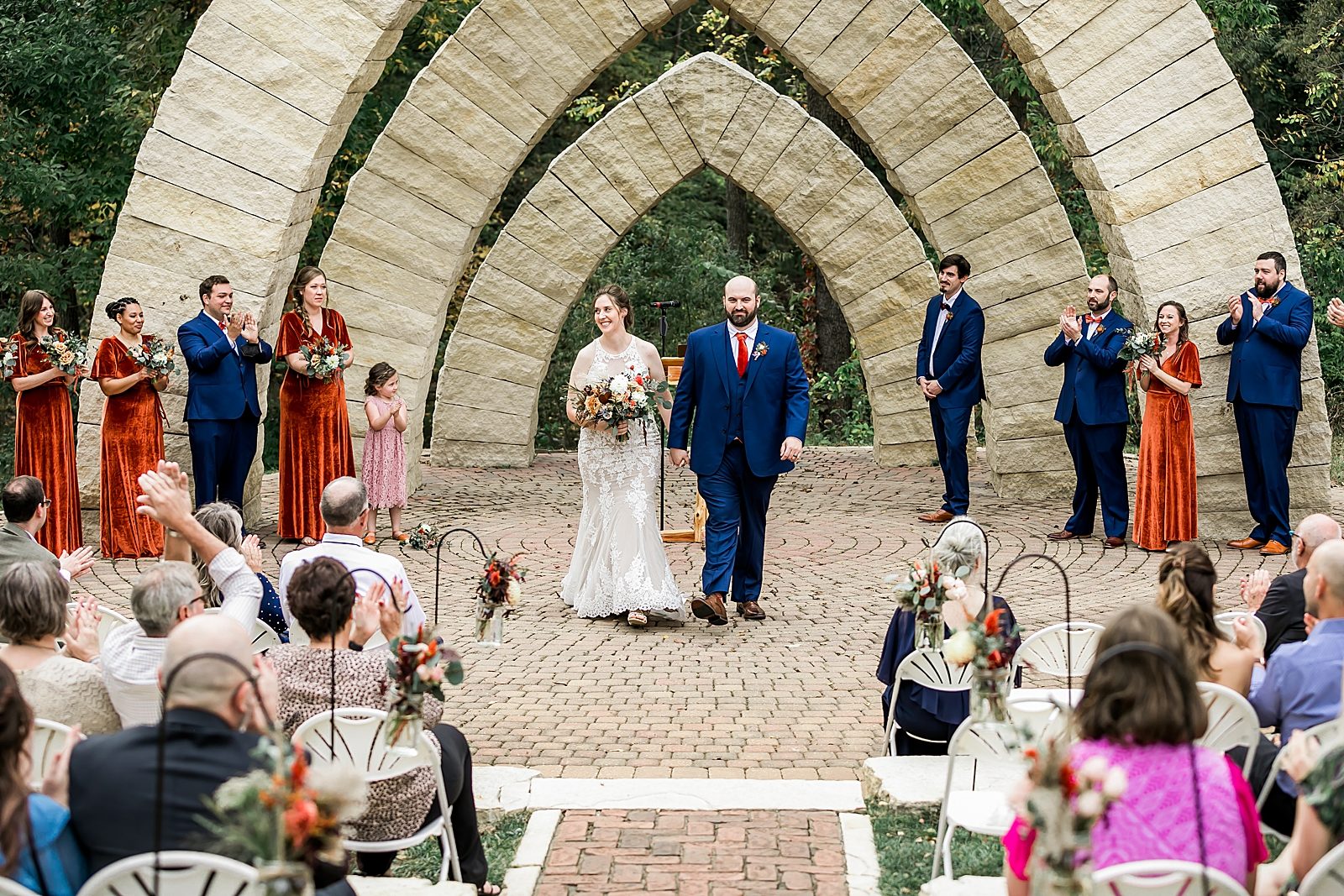 bride and groom get married under stone arches