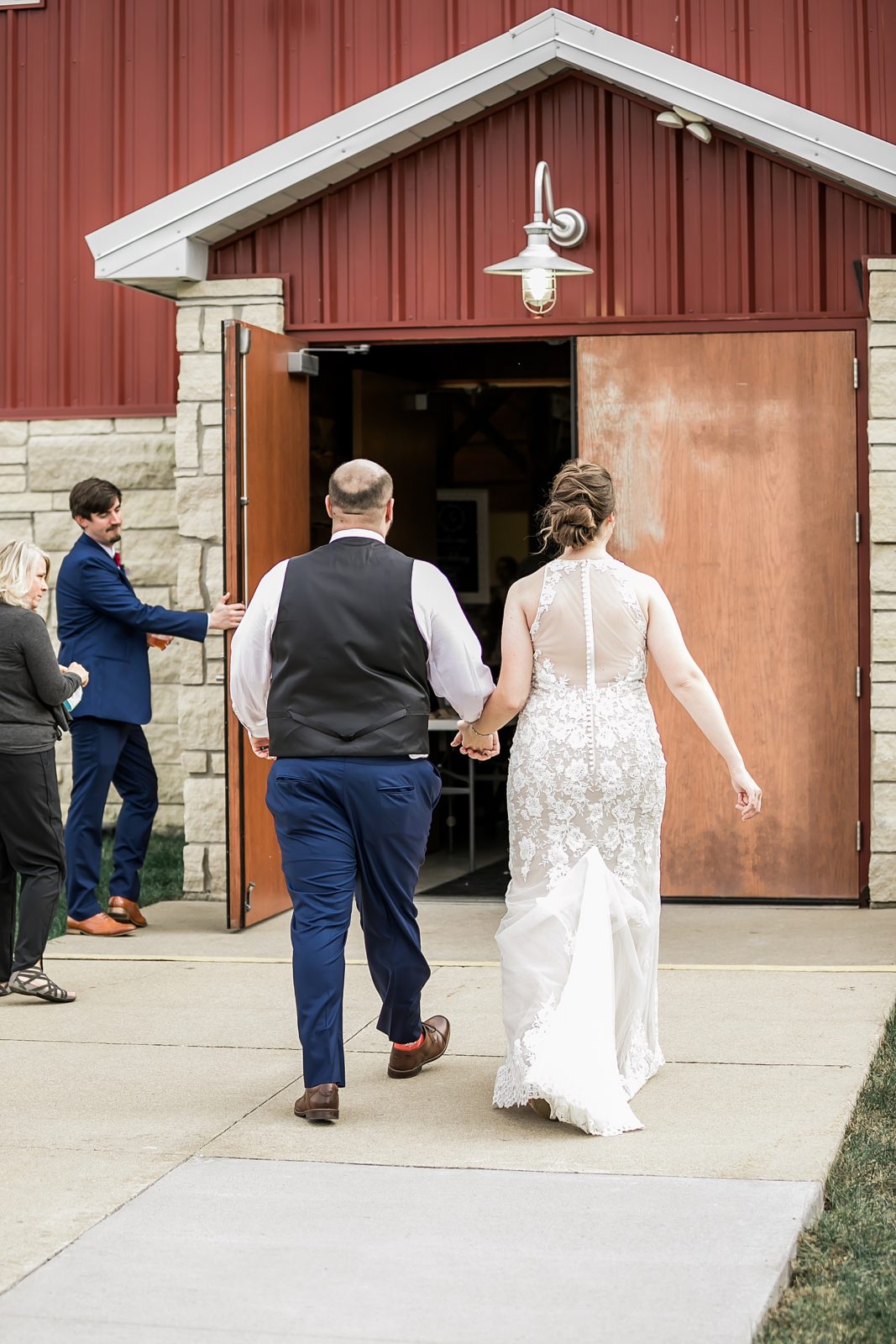 bride and groom enter reception barn