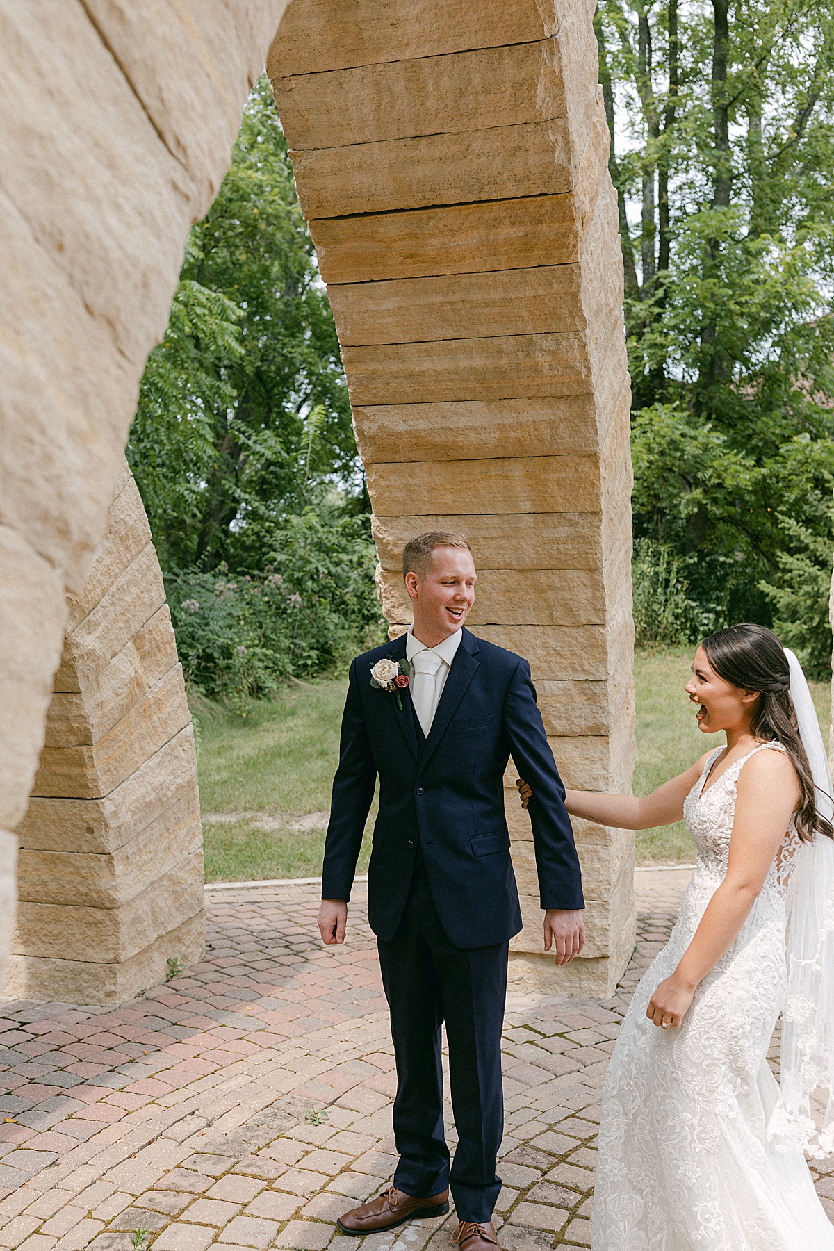 bride and groom first look under stone arches