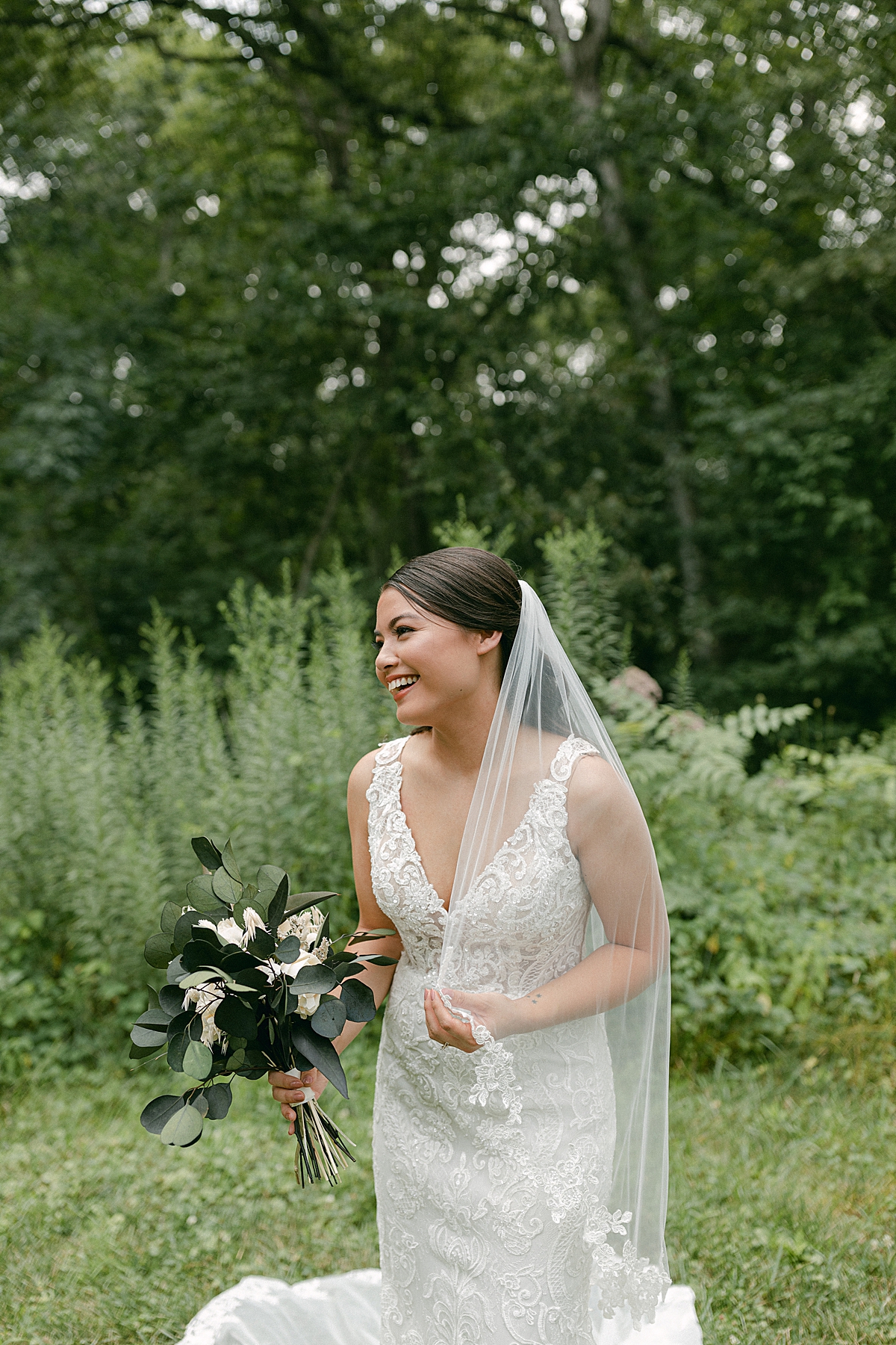 bride laughing in park with flowers