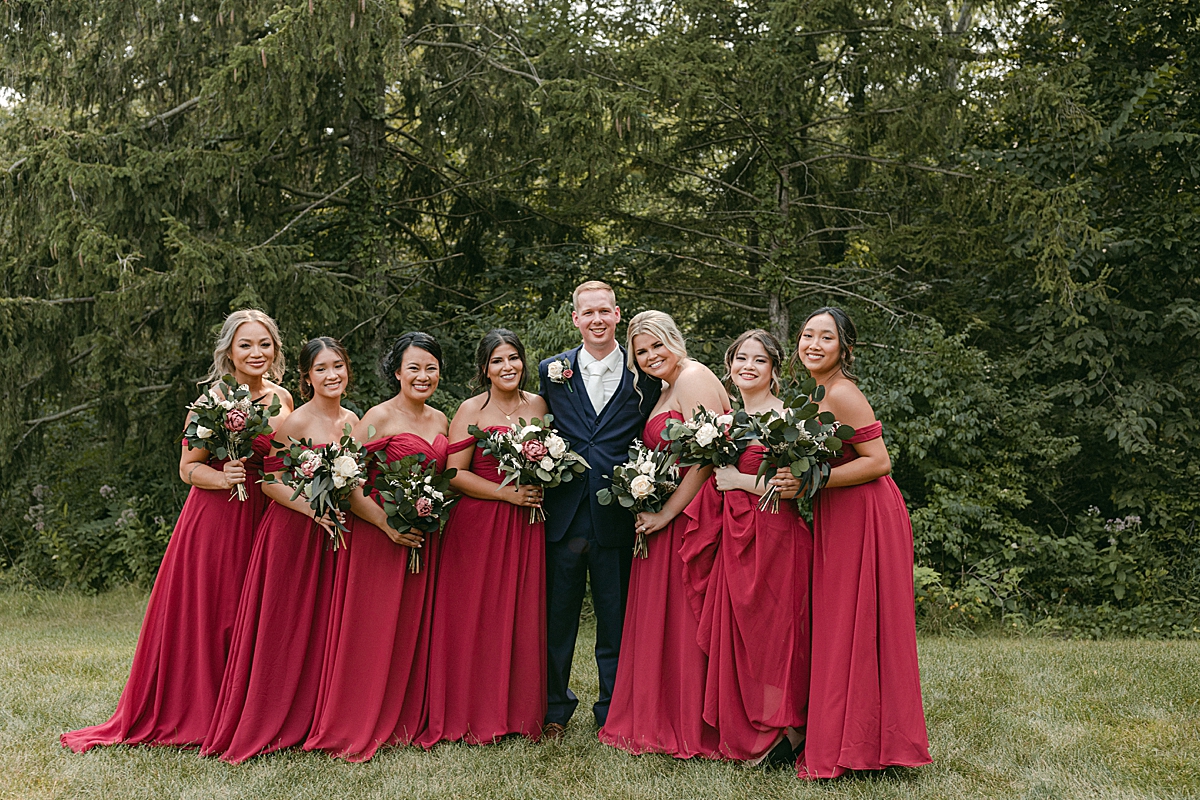groom with bridesmaids in red dresses