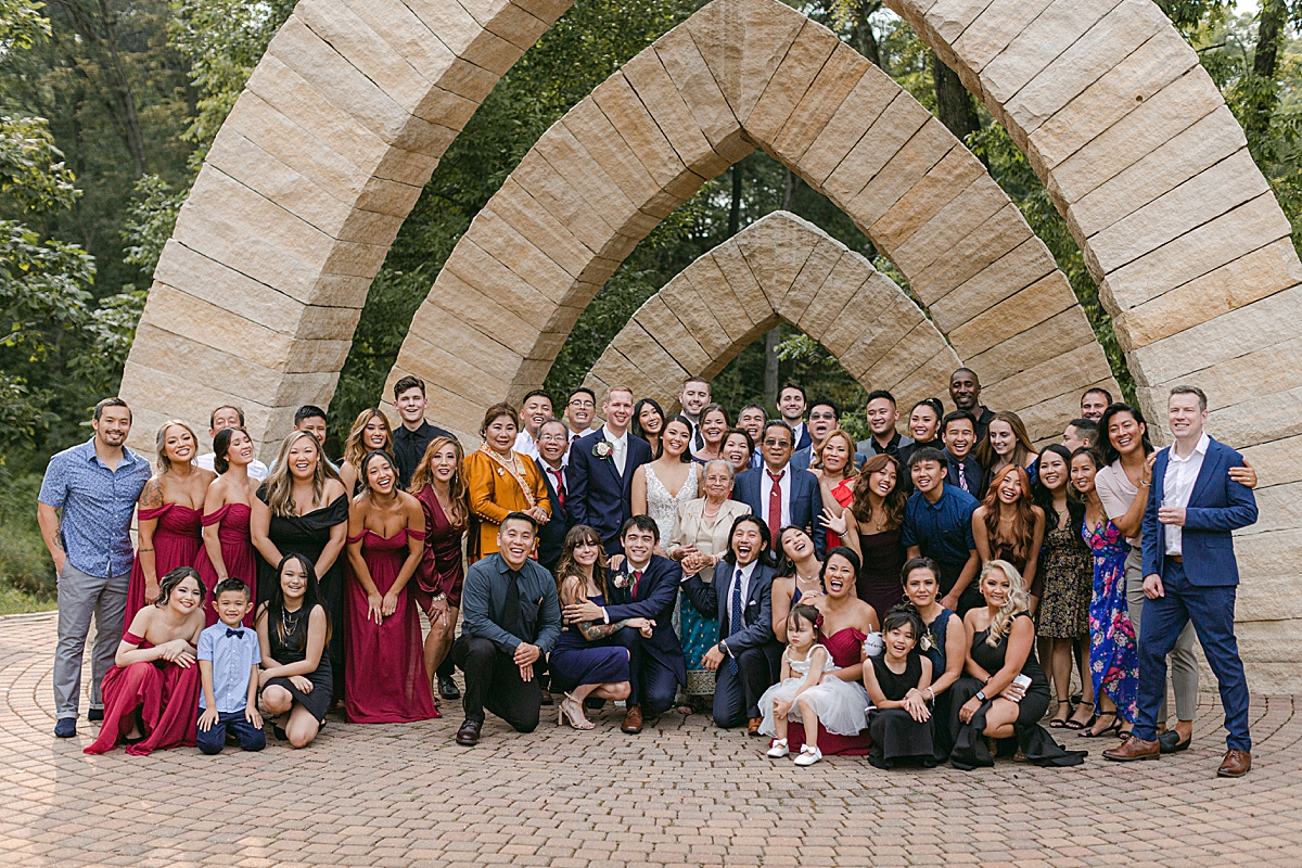 wedding guests group shot under stone arches