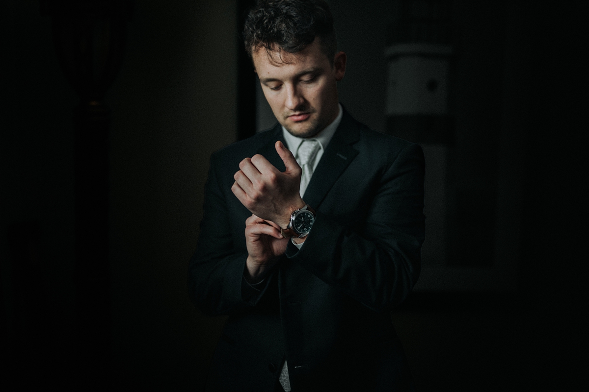 Groom putting on watch while getting ready