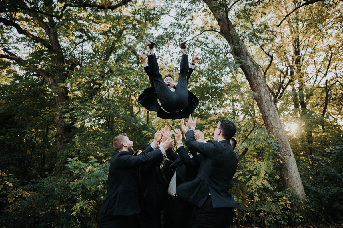 groomsmen throwing groom in air