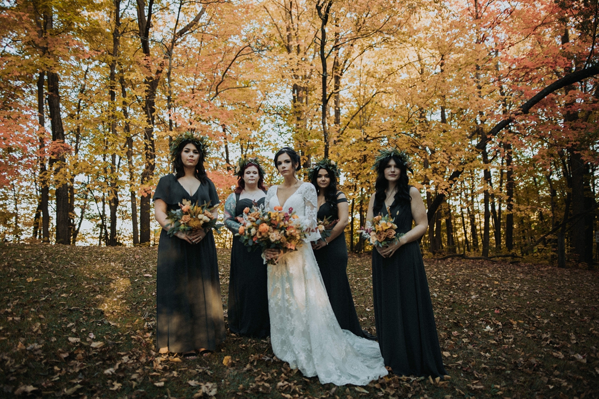 bride and bridesmaids dark fall woods yellow leaves portrait