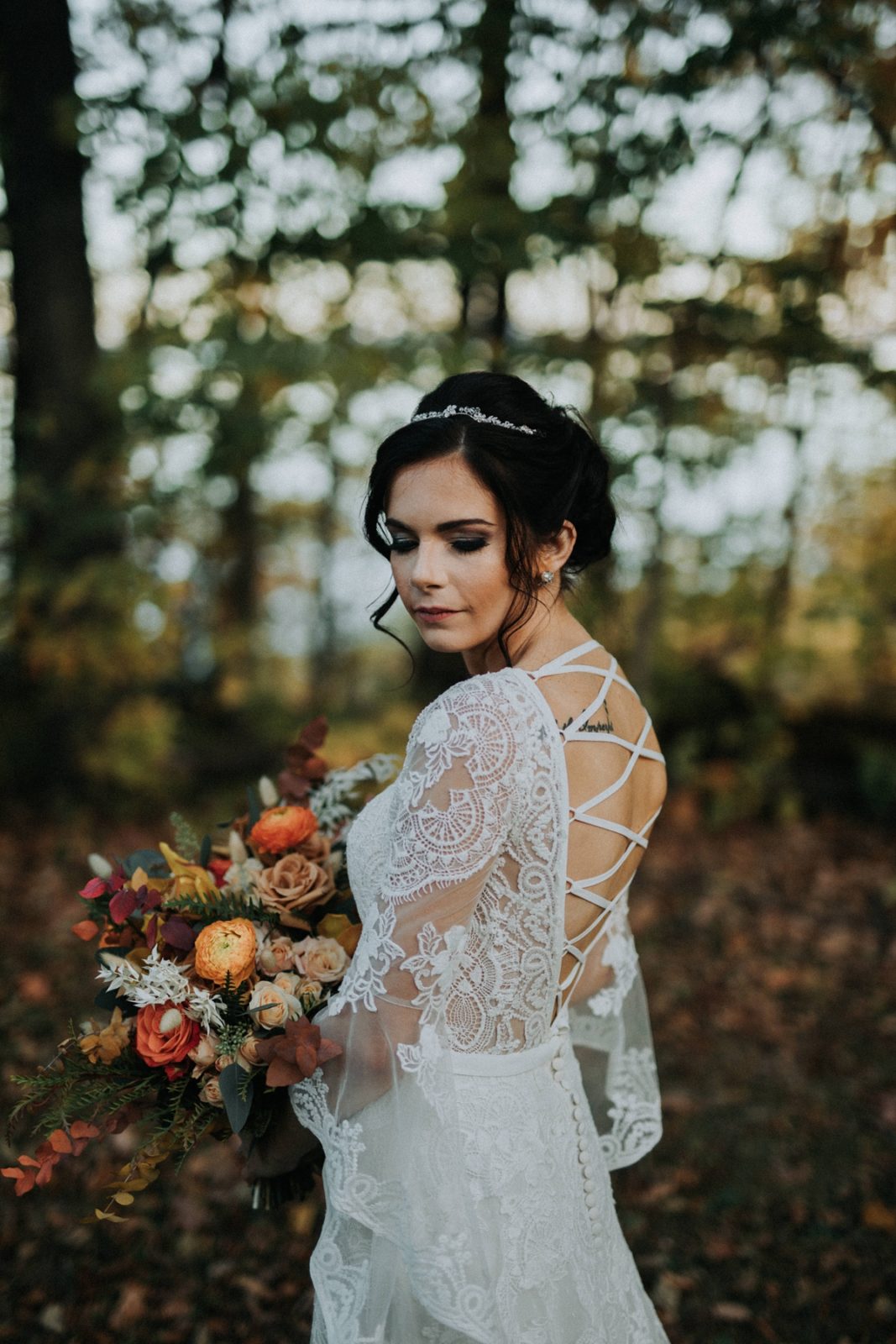 bride with laced back dress in park