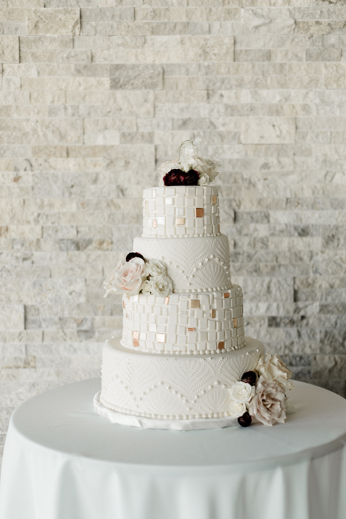 four tiered white and gold wedding cake