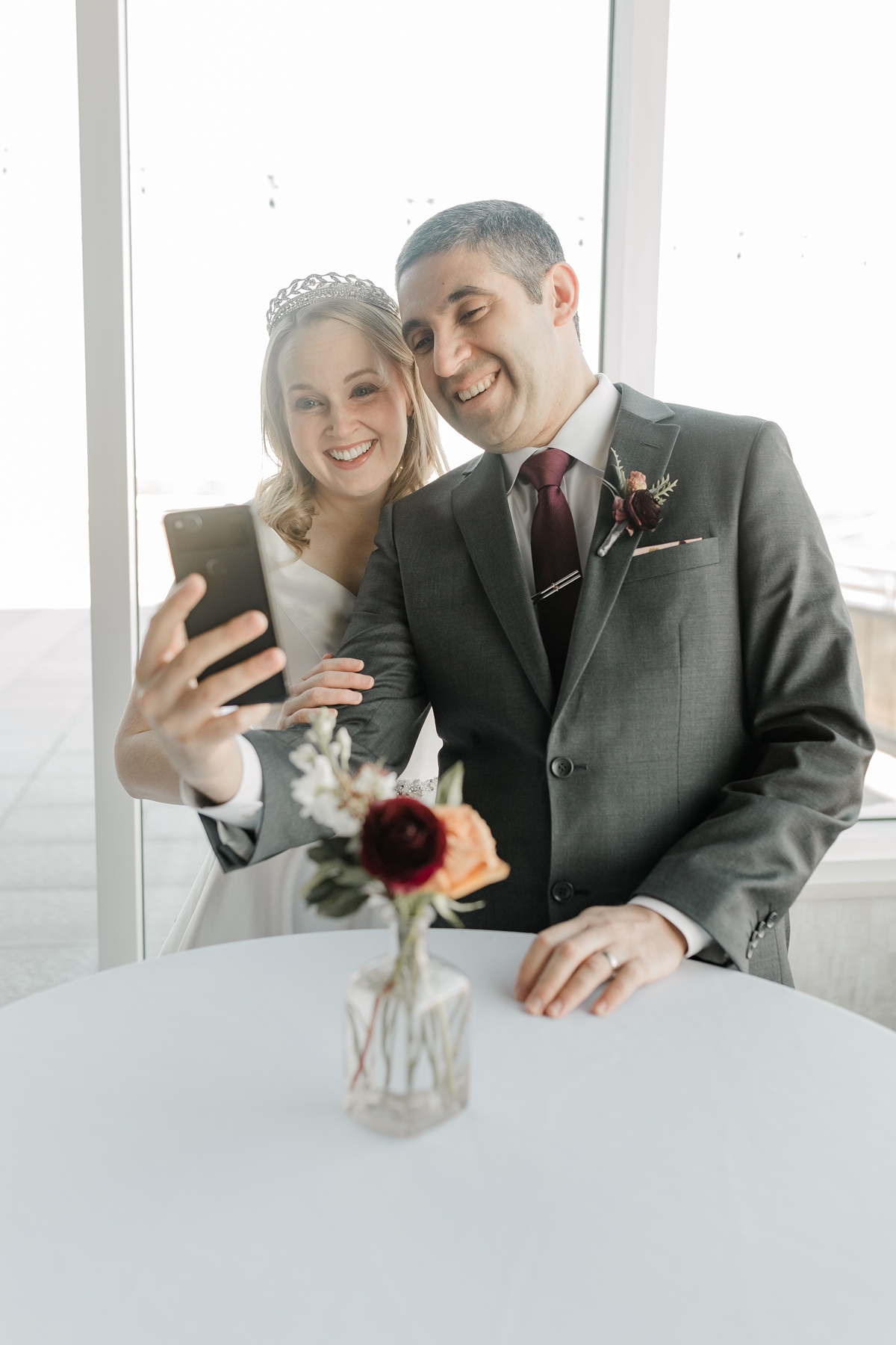 bride and groom facetiming family at wedding