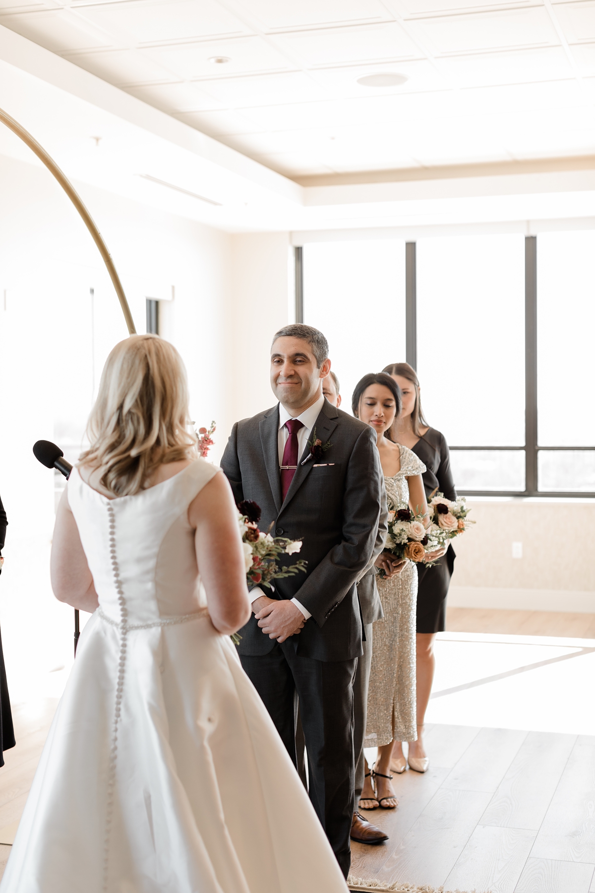Groom smiling at bride during vows