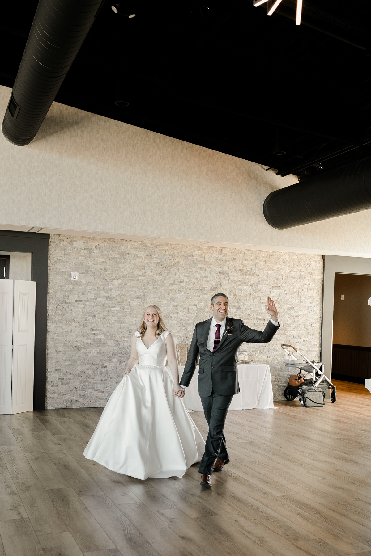 bride and groom entering reception with wave