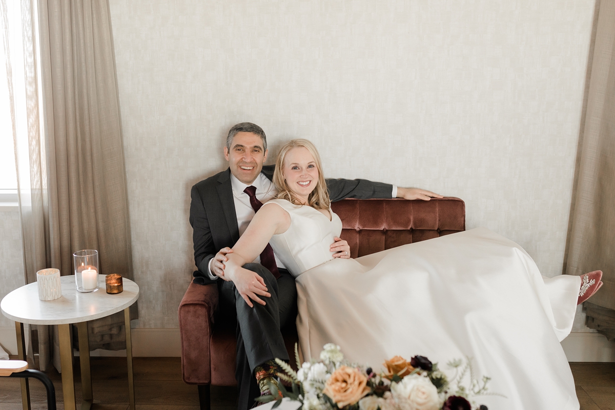 bride and groom portrait cuddling on velvet couch