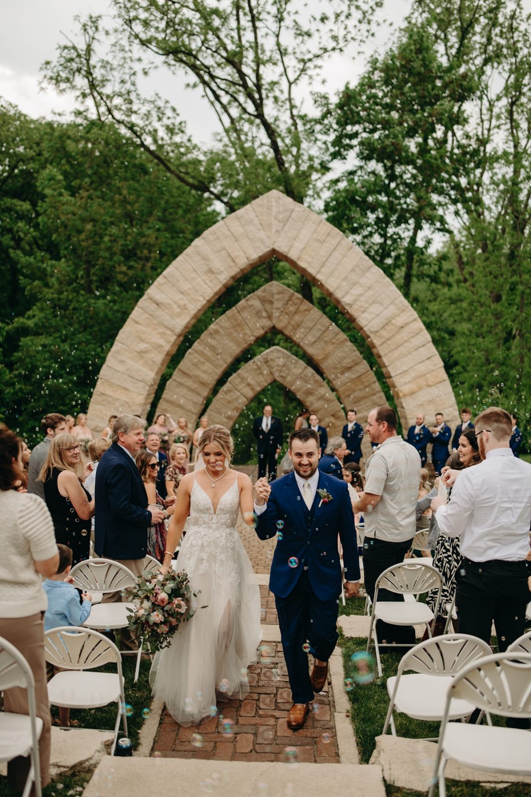 Couple walking away from arches at Celebration Farm Wedding Iowa City