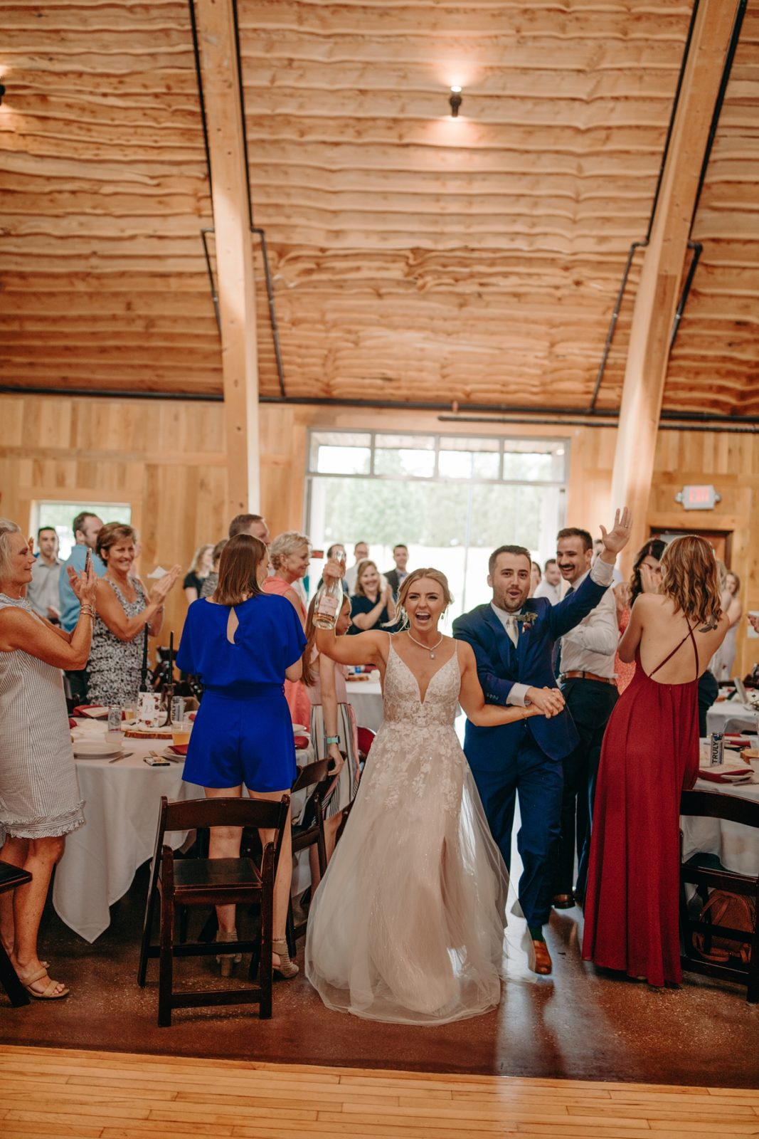 bride and groom cheersing as they enter reception at Celebration Farm Wedding Iowa City