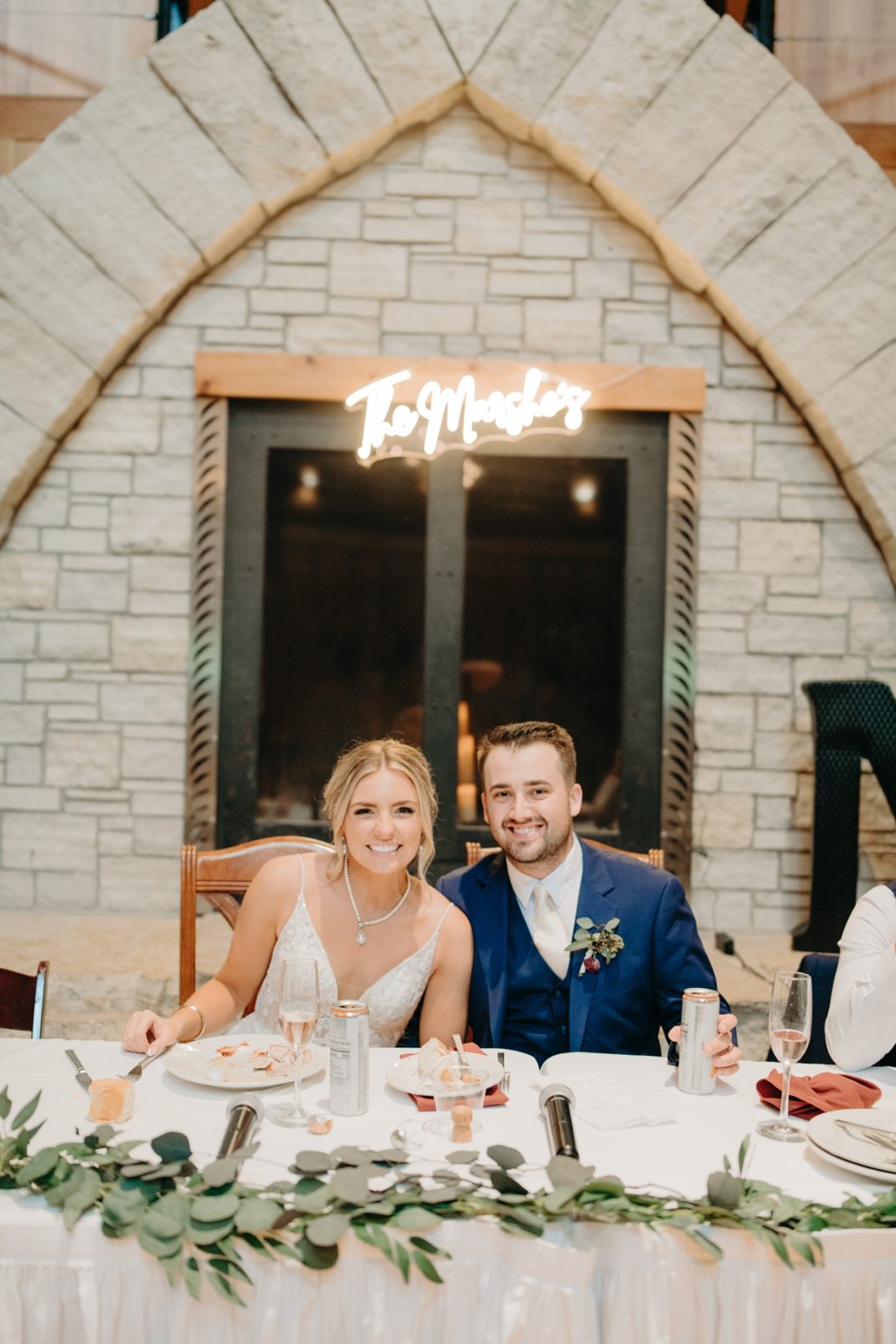 Bride and groom in front of custom neon sign at Celebration Farm Wedding reception in Iowa City