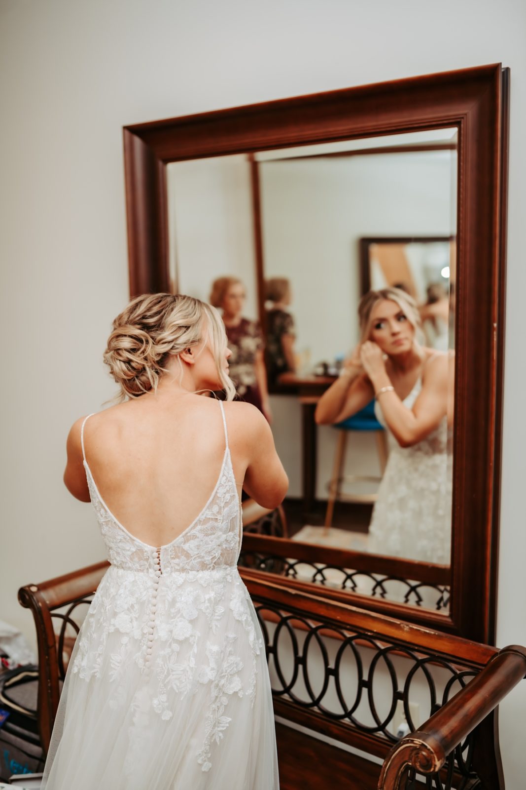 Bride putting on earrings while getting ready in Iowa City, Iowa