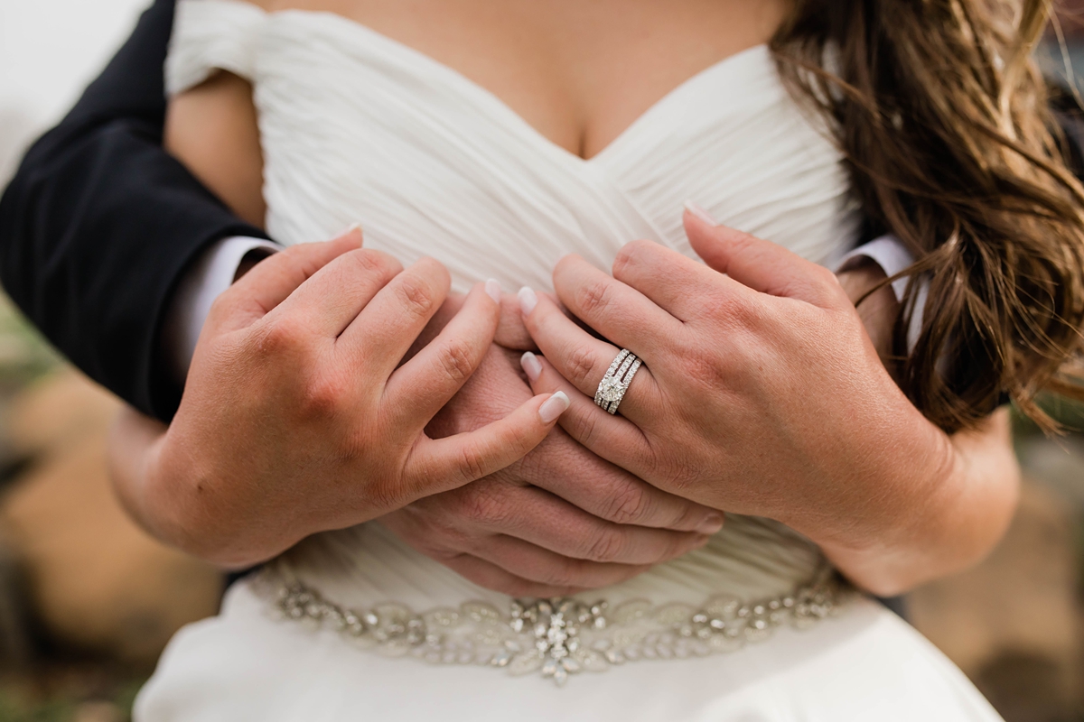 Close up of bride and grooms hands together.