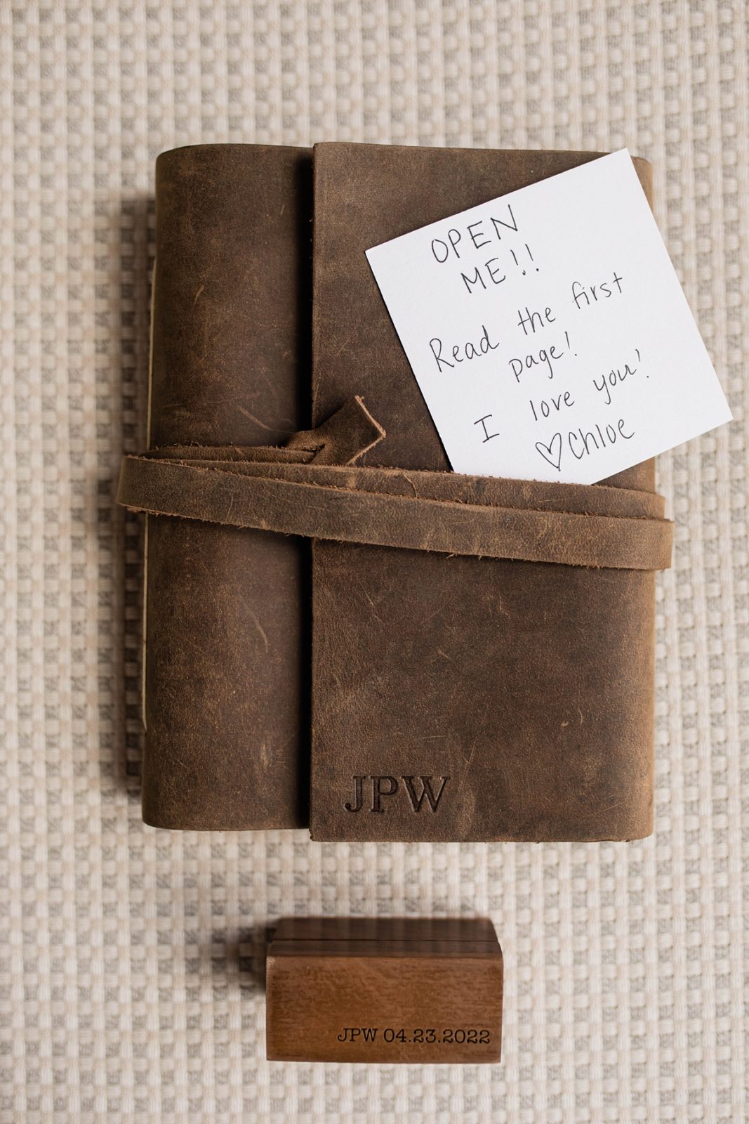 Bride's note to groom with custom engraved leather book before ceremony.