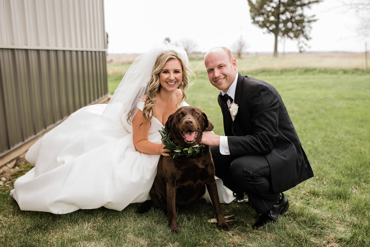 Bride and groom with their dog on wedding day.