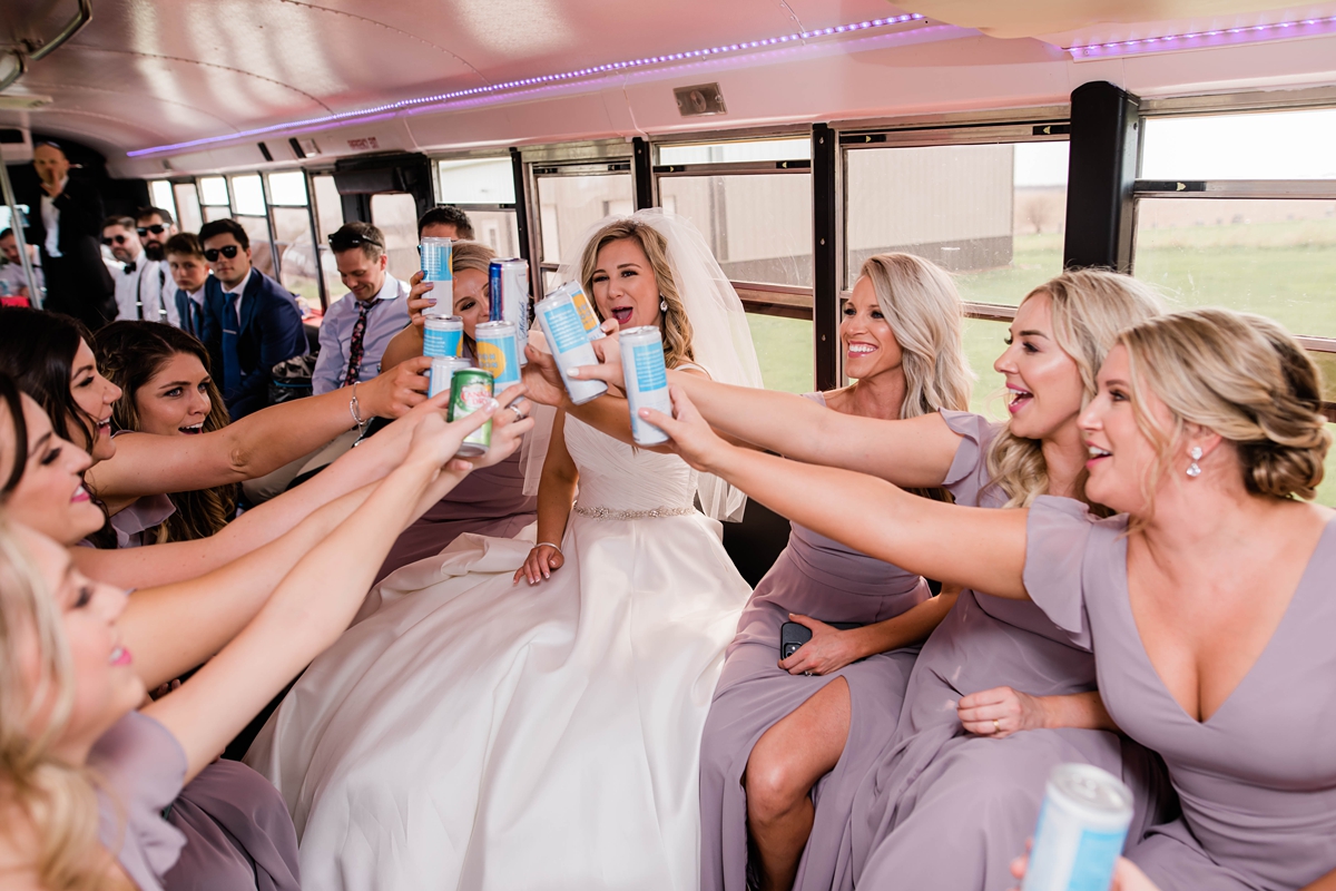 Wedding party cheersing on bus.