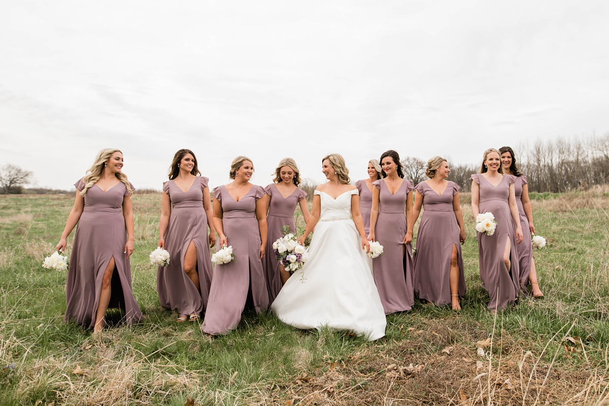 Bridal party in purple dresses walking with bride