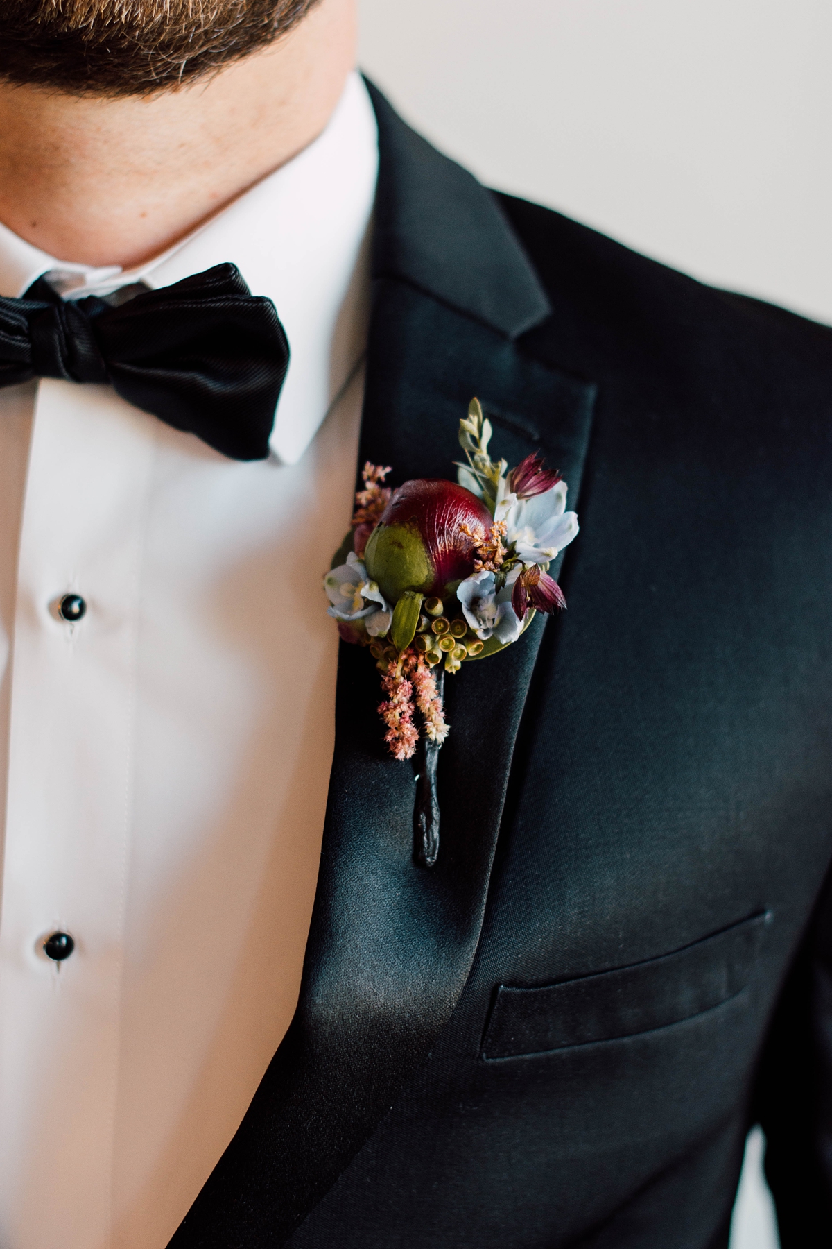 Gathering Barn Williamsburg Iowa Wedding maroon boutonniere with black tux and bowtie