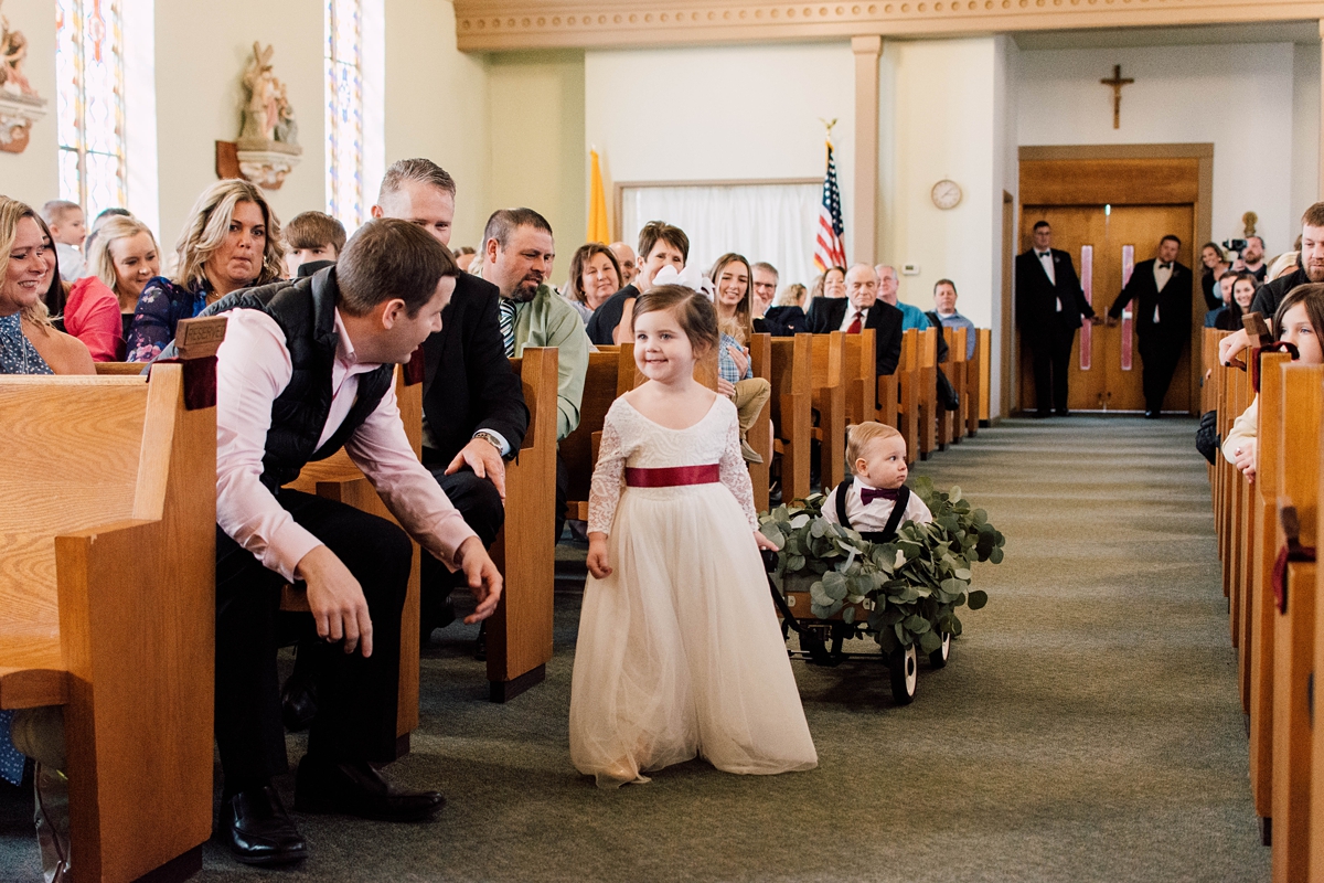 St Peter's Catholic Church in Oxford Iowa wedding flower girl and ring bearer in wagon