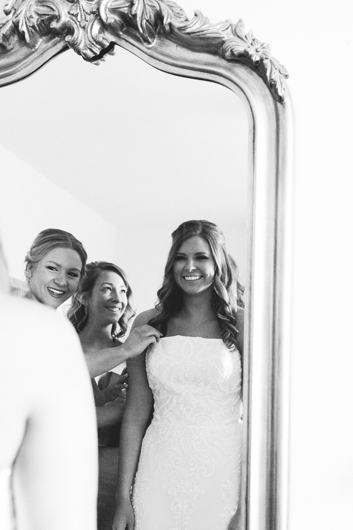 Gathering Barn Williamsburg Iowa Wedding bridesmaids and bride smiling at eachother in mirror