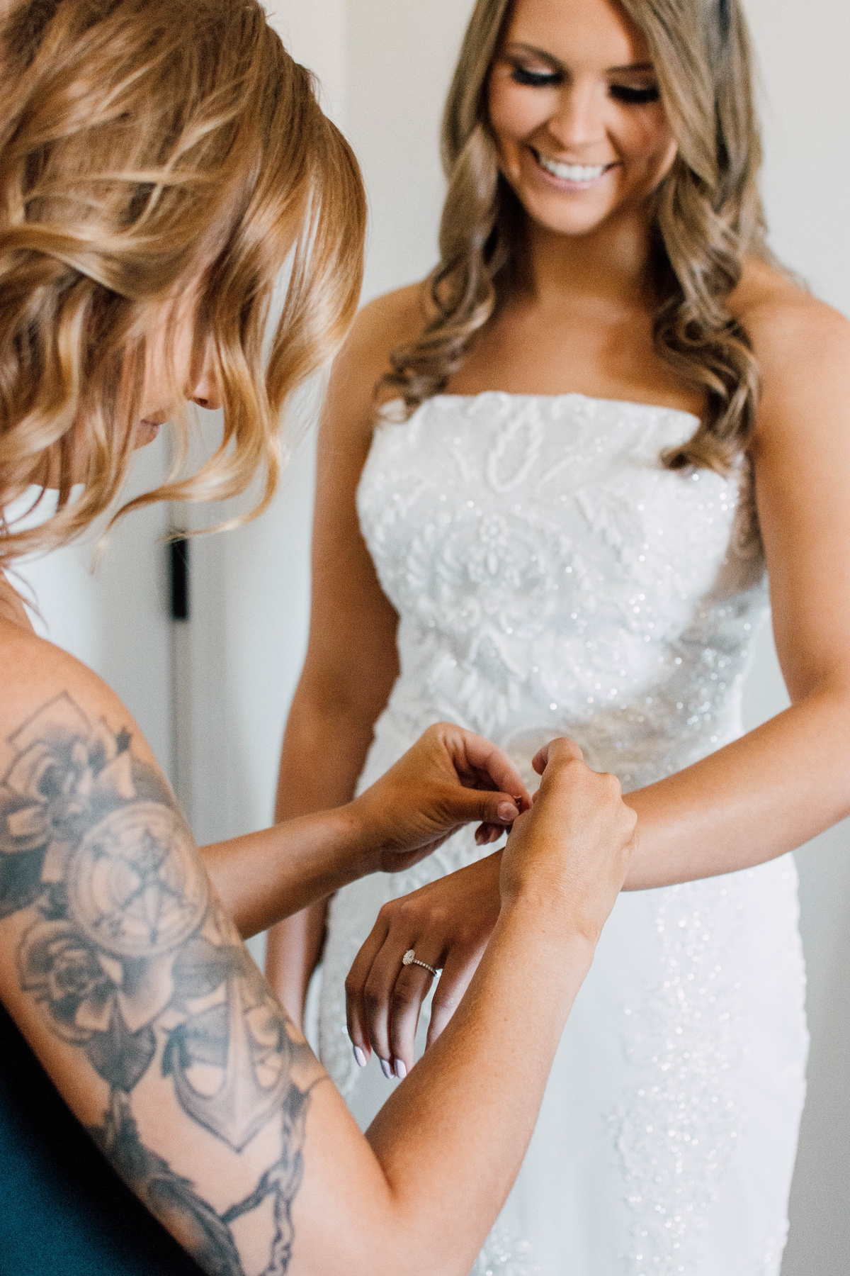 Gathering Barn Williamsburg Iowa Wedding bridesmaid fastening bride's bracelet