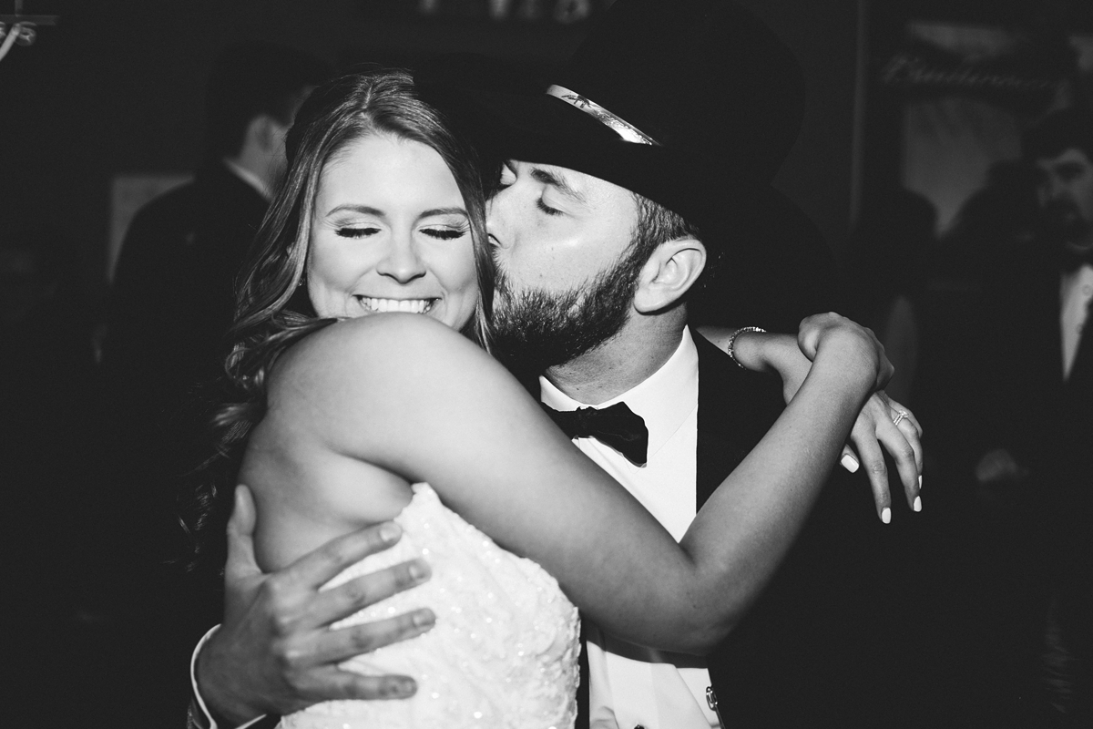 Gathering Barn Williamsburg Iowa Wedding bride and groom kissing at reception party