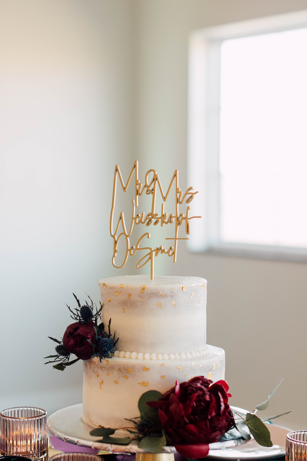 Gathering Barn Williamsburg Iowa Wedding white cake with gold name topper