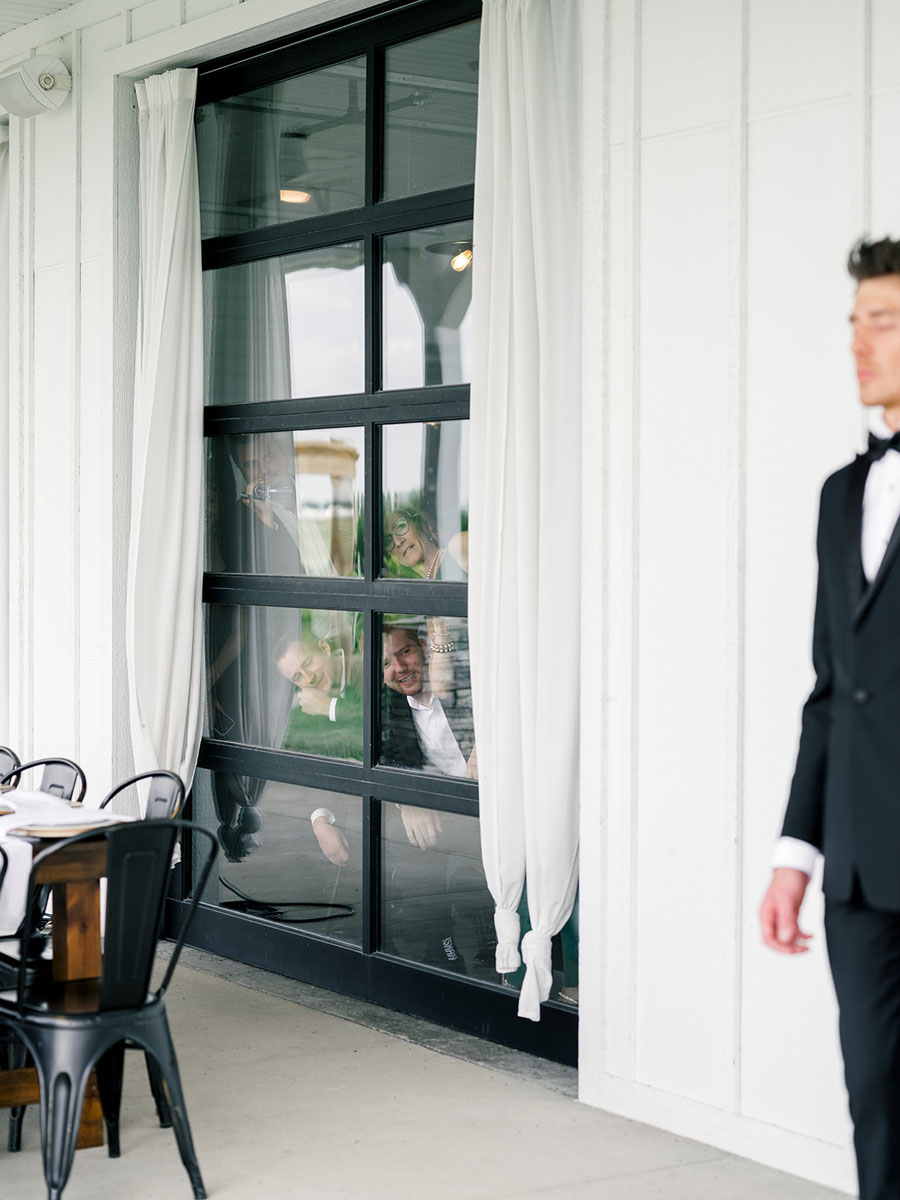 Guests peeking out the window during the couple's First Look