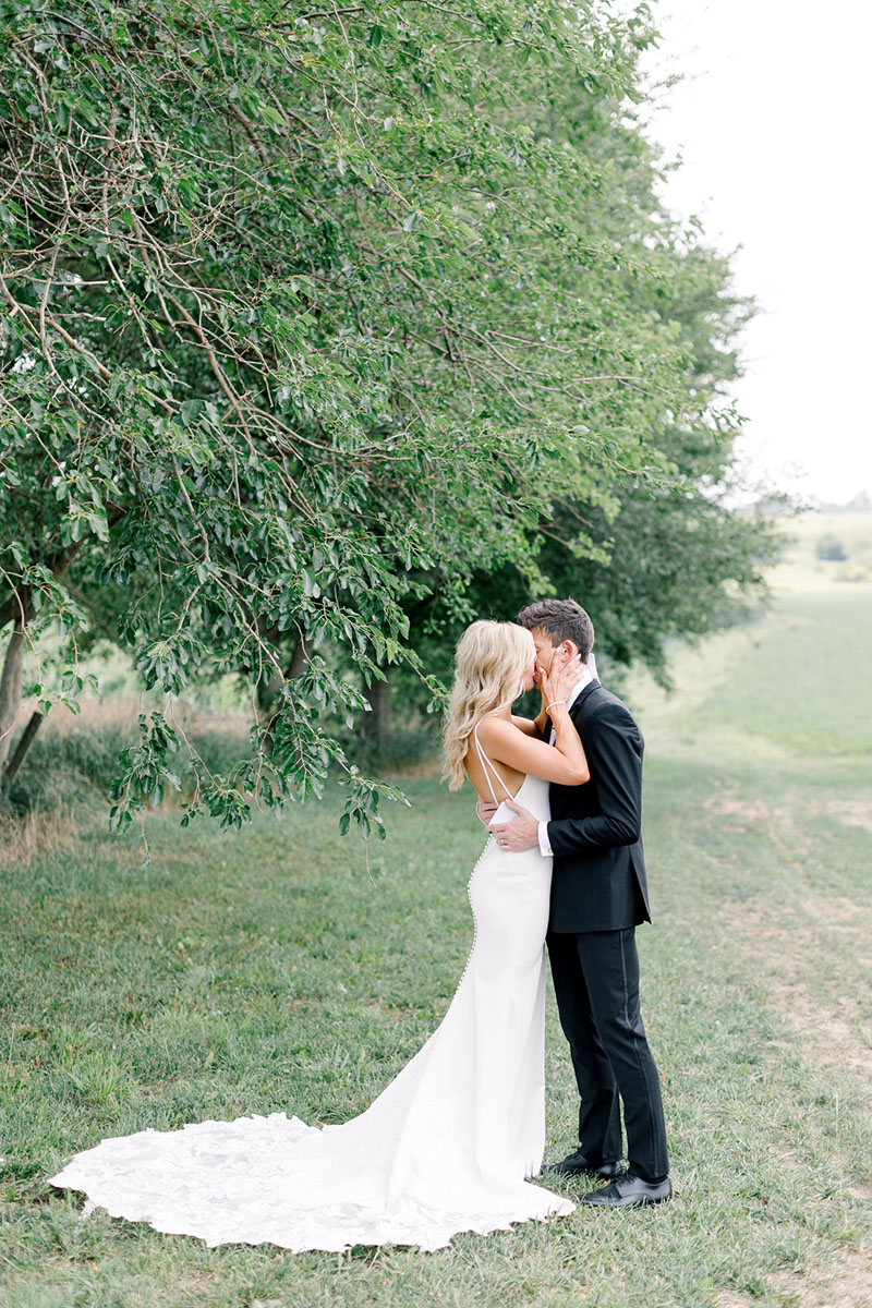 bride groom kissing by tree walker homestead